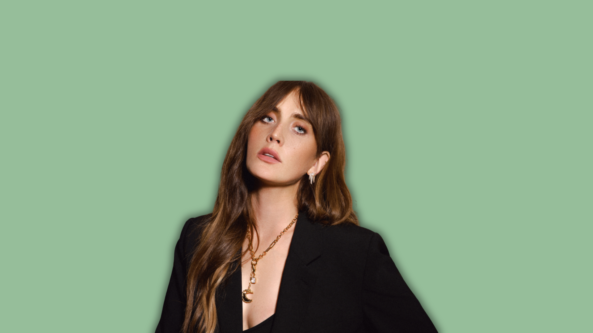 Photo of a woman wearing Orelia jewellery on a green background